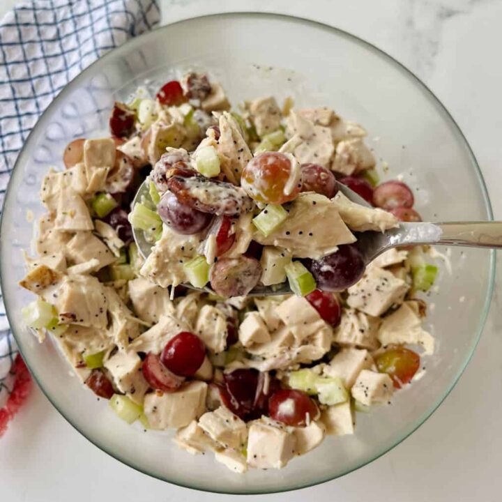 Fresh chicken salad with grapes, celery, and herbs in a glass bowl.