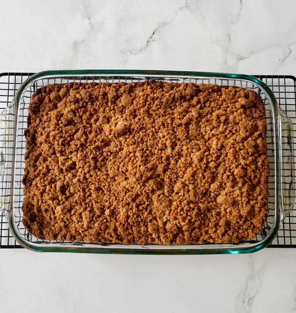 Baked coffee cake with crispy golden topping in glass dish.