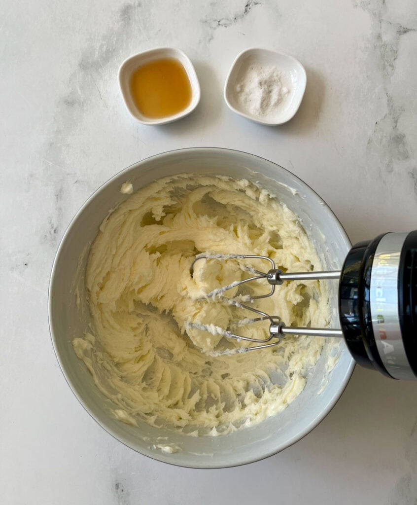 Mixing butter and sugar in a bowl with hand mixer for baking.