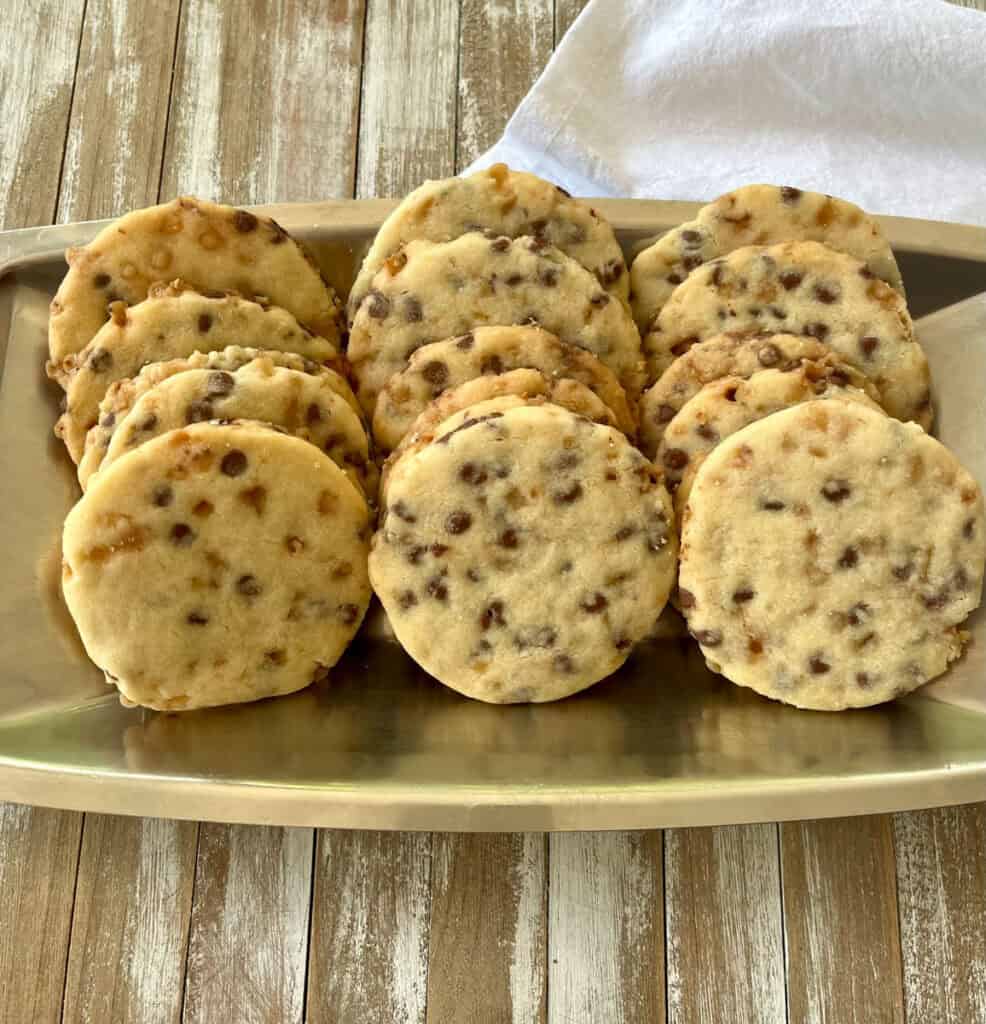 Freshly baked shortbread cookies with chocolate chips and toffee bits on a serving dish.
