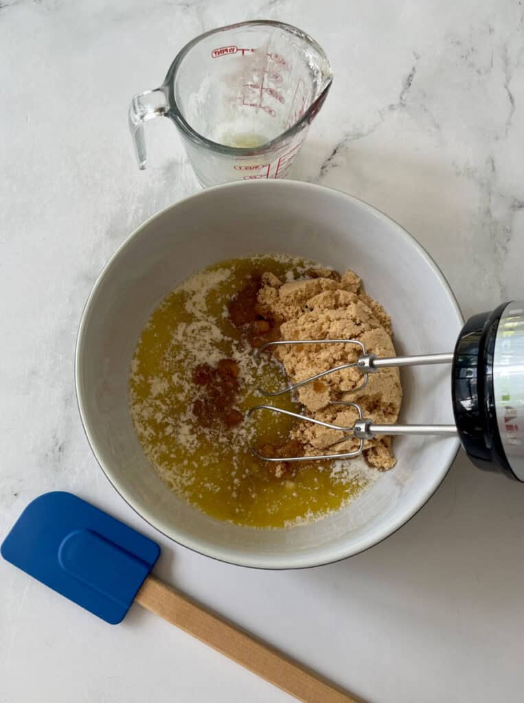 Mixing bowl with brown sugar and melted butter for baking.