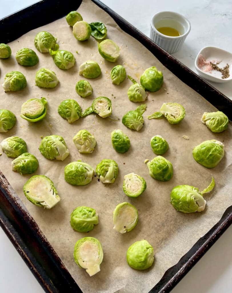 Fresh Brussels sprouts on baking sheet ready for roasting.