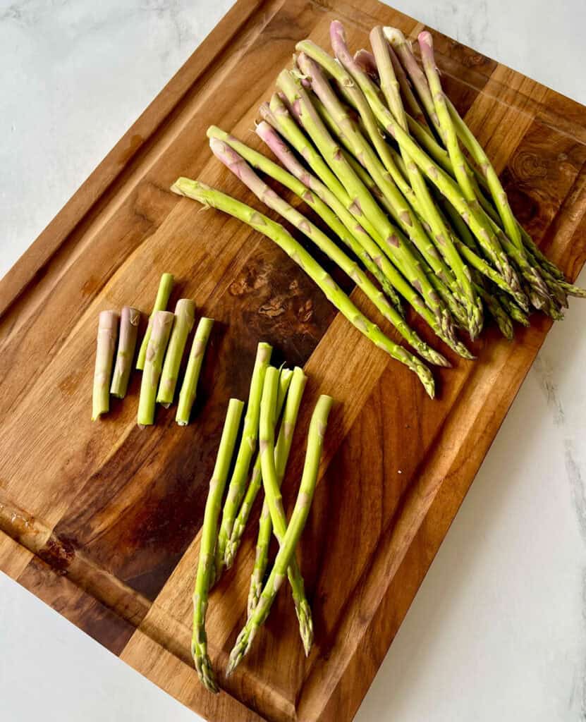 Fresh green asparagus spears on a wooden cutting board.