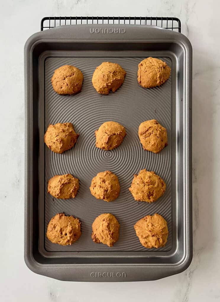Freshly baked pumpkin cookies on a baking sheet.